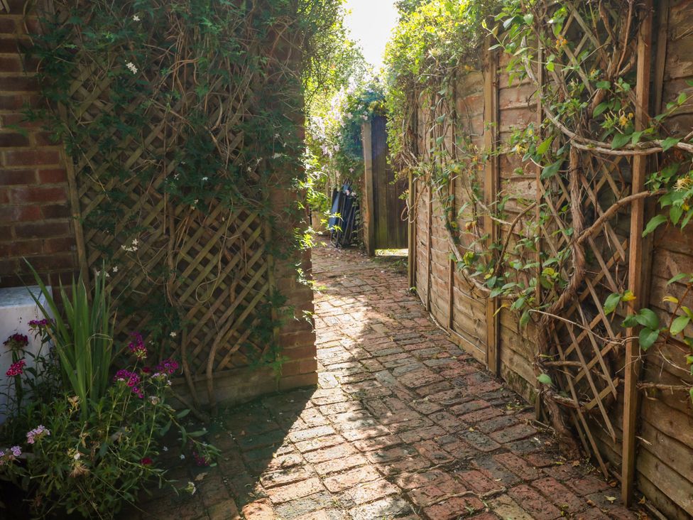 A garden path with plants and lattice at Lucerne Cottage Dorking