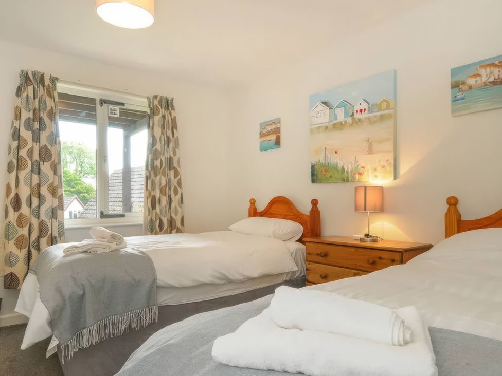 A bedroom with two single beds and a lamp at 9 Honicombe Park in Callington