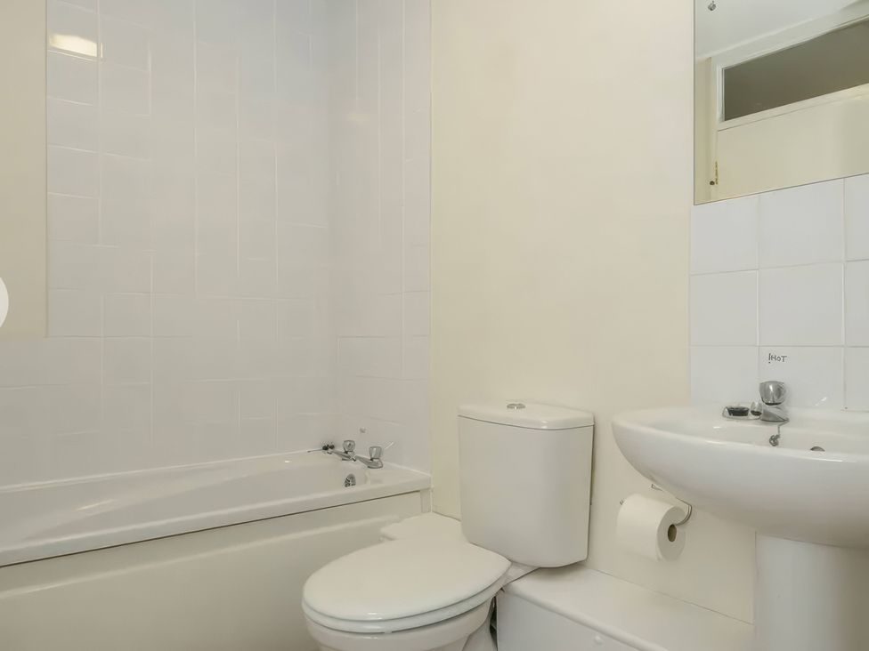 A bathroom with a bathtub, toilet, and sink at 9 Honicombe Park in Callington