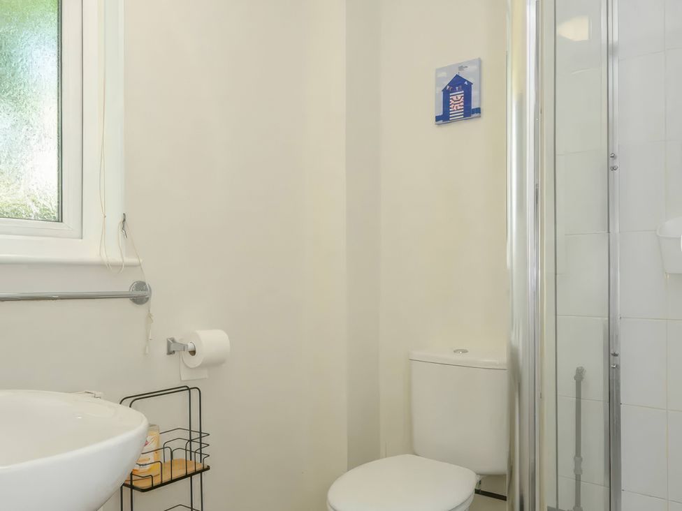 A bathroom with a washbasin, toilet, and shower at 9 Honicombe Park, Callington