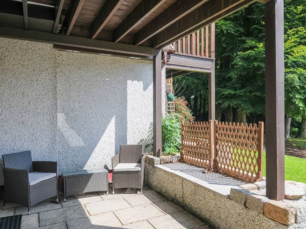 A patio area with chairs and a fence at 9 Honicombe Park in Callington