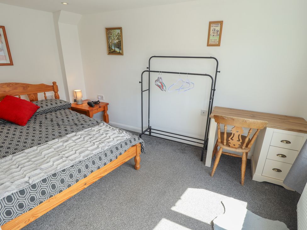 A bedroom with a bed, desk, and clothes rack at Number 3 Old Boston Road in Coningsby
