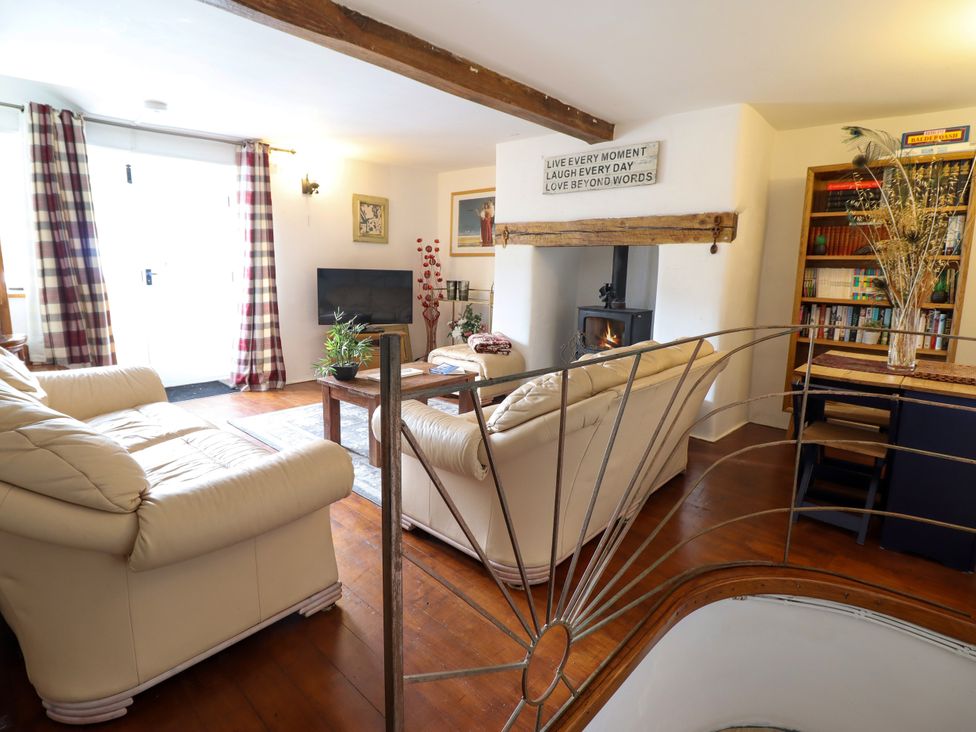 A living room with sofa and television at Hud Y Coed in Llangynog