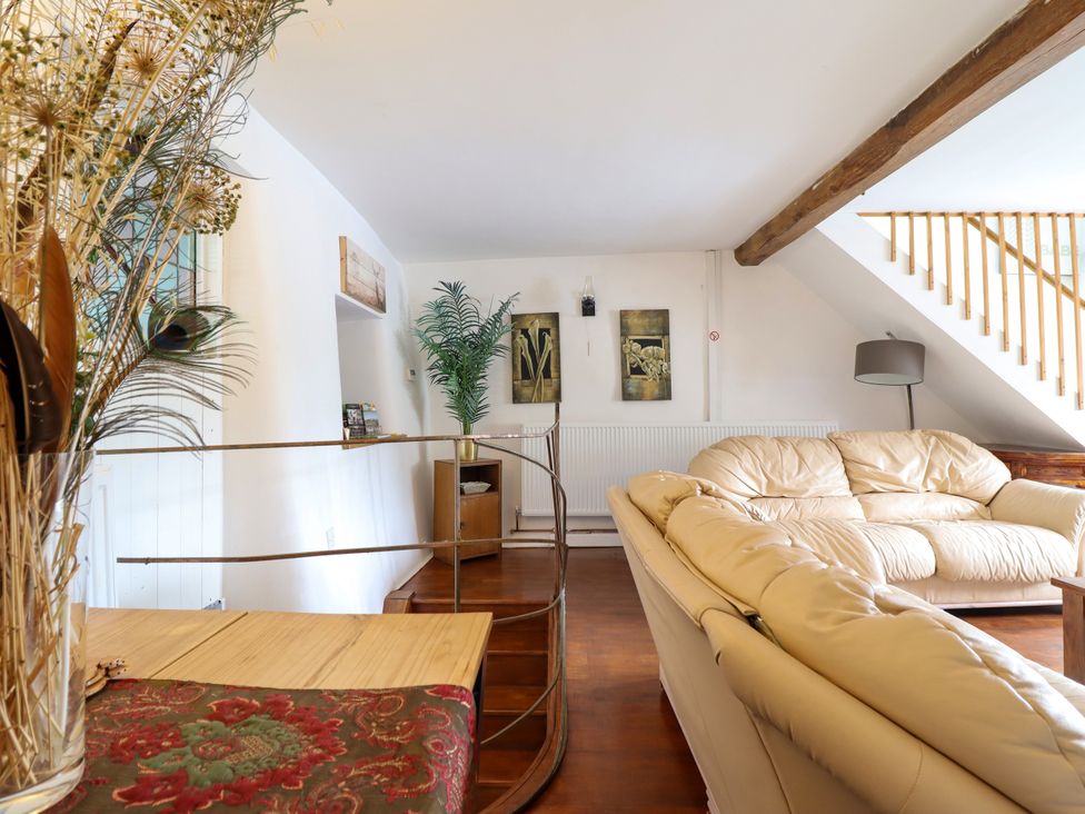 A living room with a sofa and artwork at Hud Y Coed in Llangynog