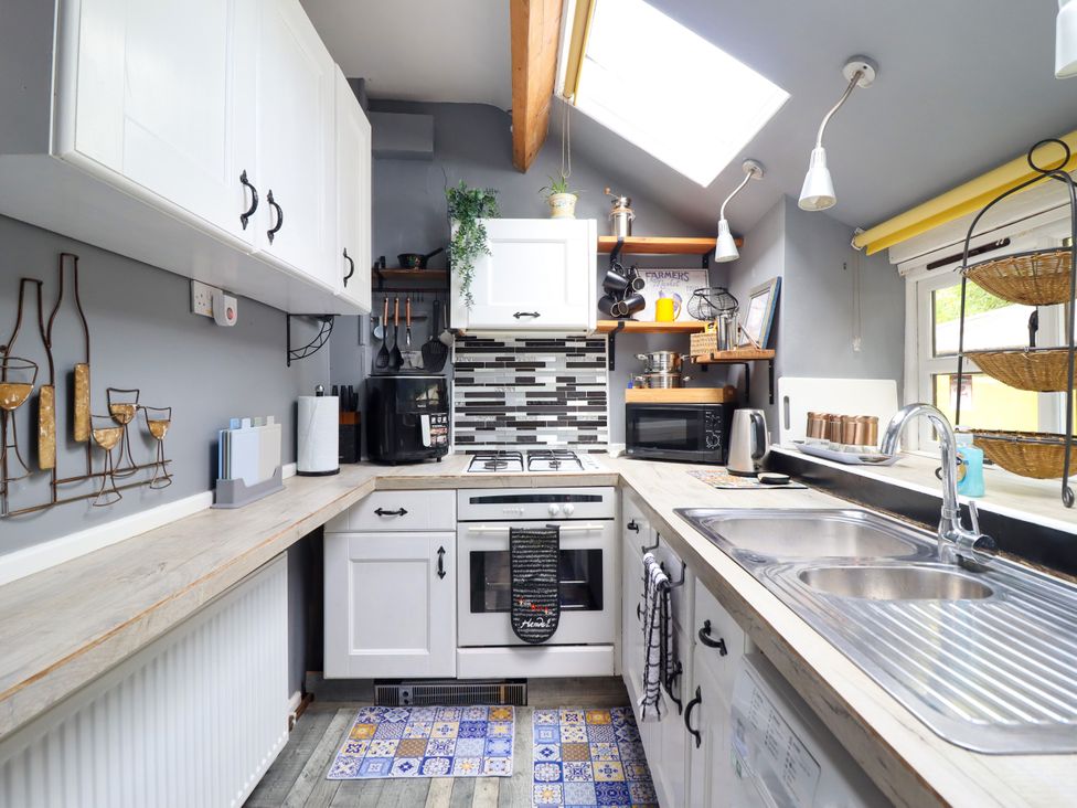A kitchen with appliances and cabinets at Hud Y Coed in Llangynog