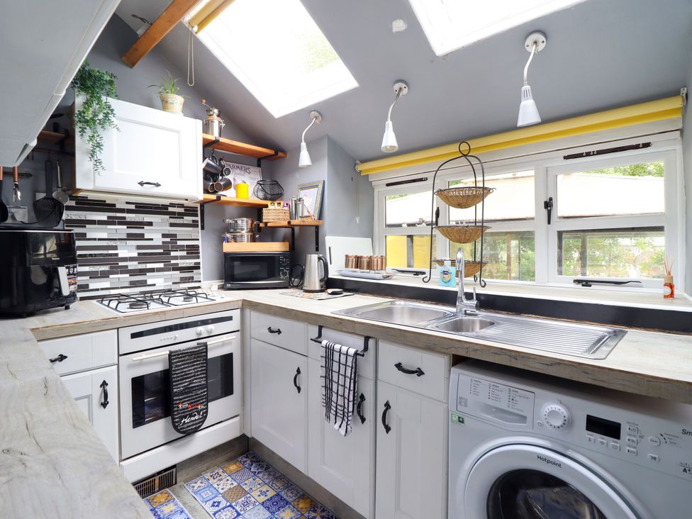 A kitchen with appliances and cabinets at Hud Y Coed in Llangynog