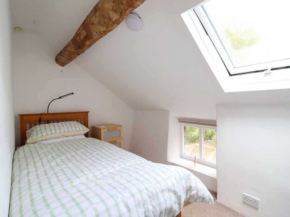 A bedroom with a bed and a skylight at Hud Y Coed in Llangynog