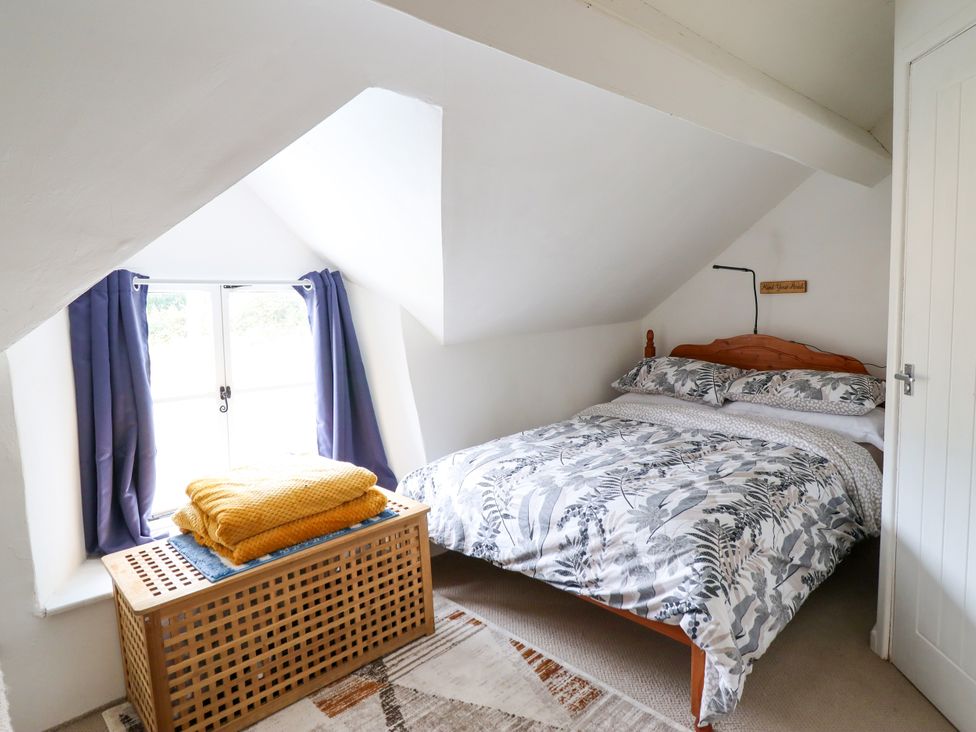 A bedroom with a bed and window at Hud Y Coed Llangynog