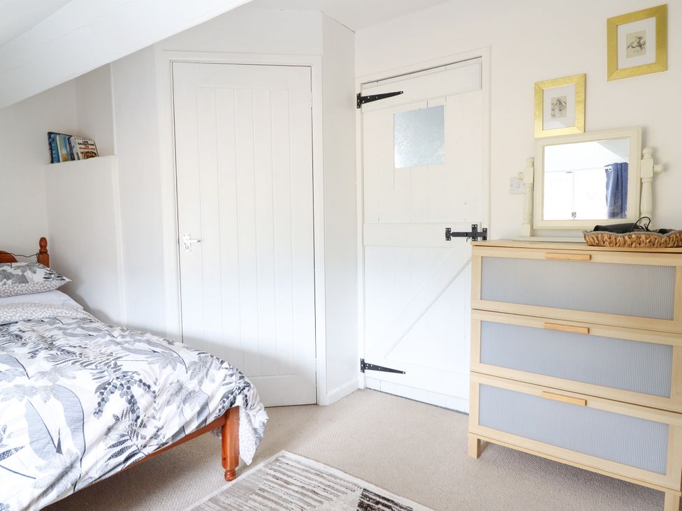 A bedroom with a bed and a drawer unit at Hud Y Coed in Llangynog