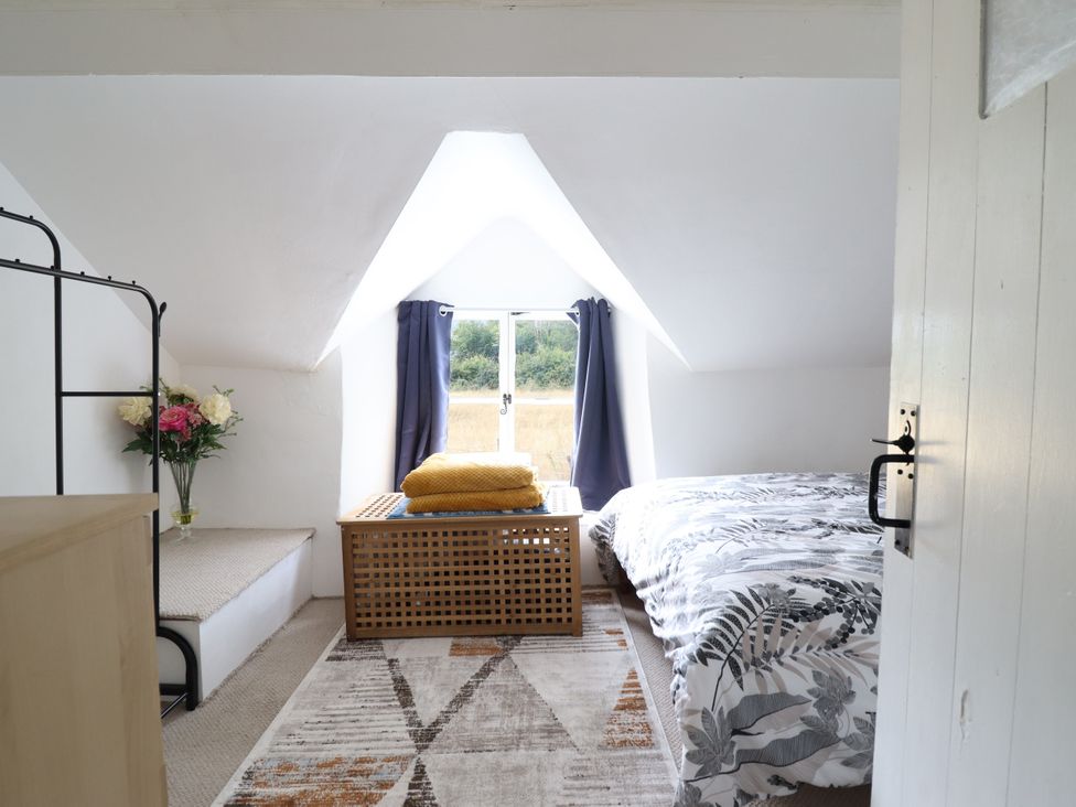 A bedroom with a bed and window at Hud Y Coed in Llangynog