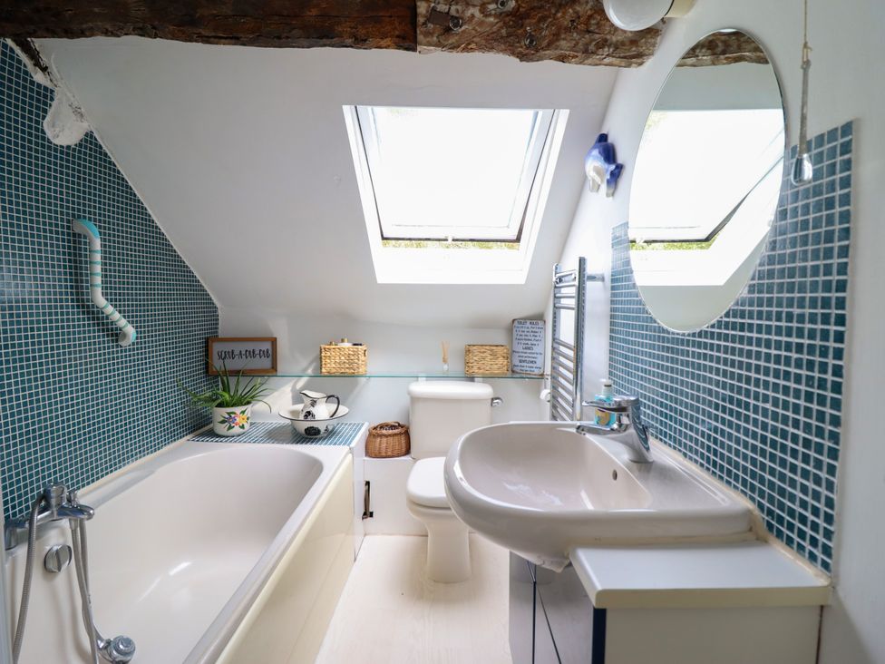 A bathroom with a bathtub and sink at Hud Y Coed in Llangynog