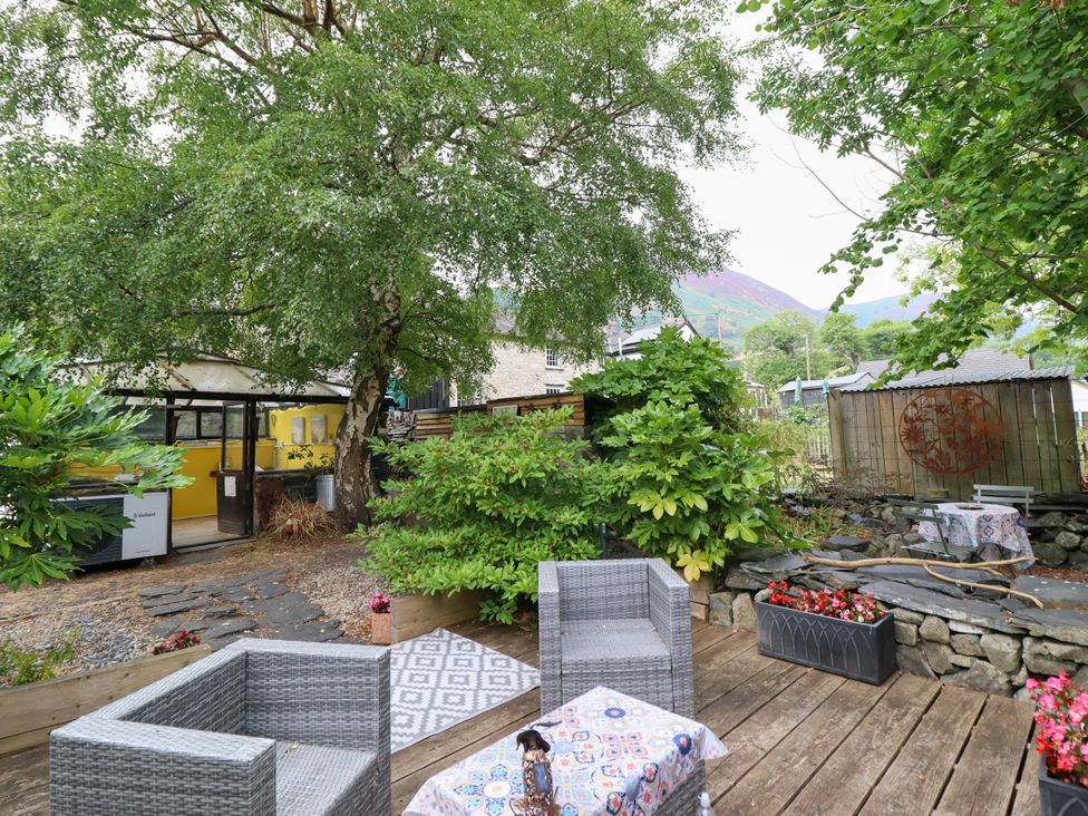 A garden with seating and table at Hud Y Coed in Llangynog
