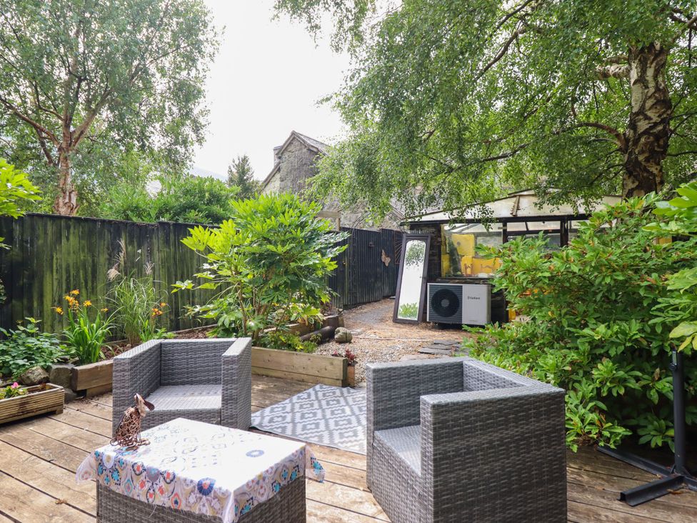 A garden area with chairs and a table at Hud Y Coed in Llangynog