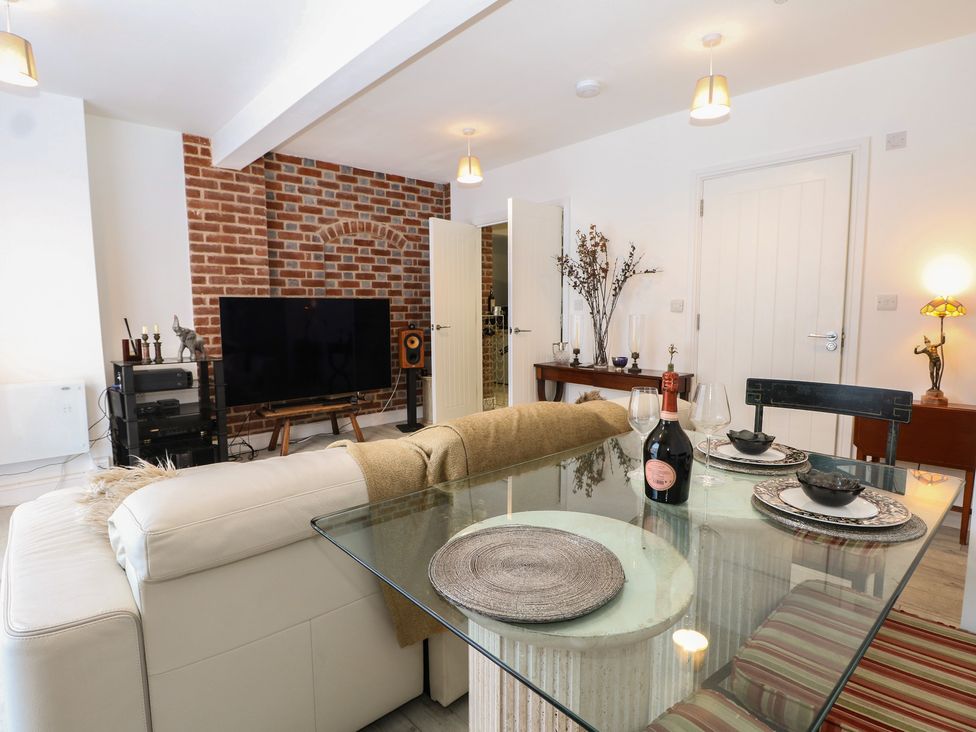 A living room with a sofa and dining table at 1 Bed in Bishop's Waltham