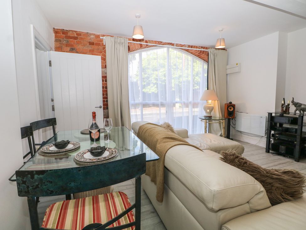 A living room with a dining table and sofa at 1 Bed in Bishop's Waltham