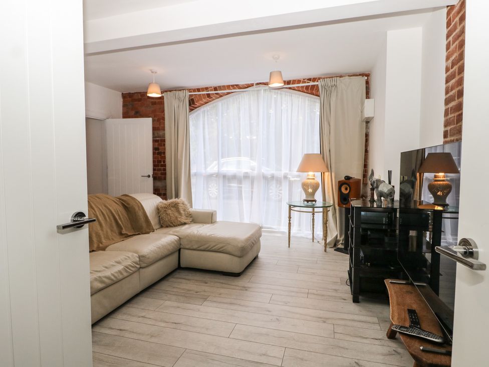 A living room with a sofa and television at 1 Bed in Bishop's Waltham