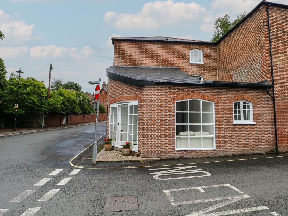 A view of a brick building corner with a road and sign at 1 Bed in Bishop's Waltham
