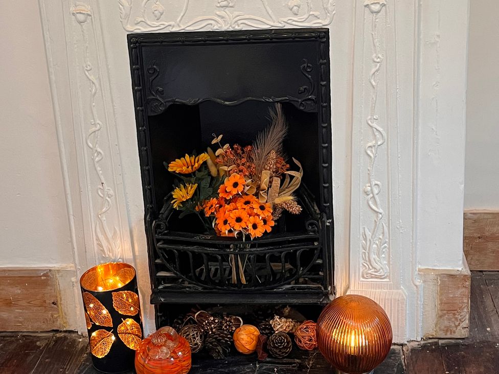 A fireplace with decorative flowers and candles at 5a Bramber Road Seaford