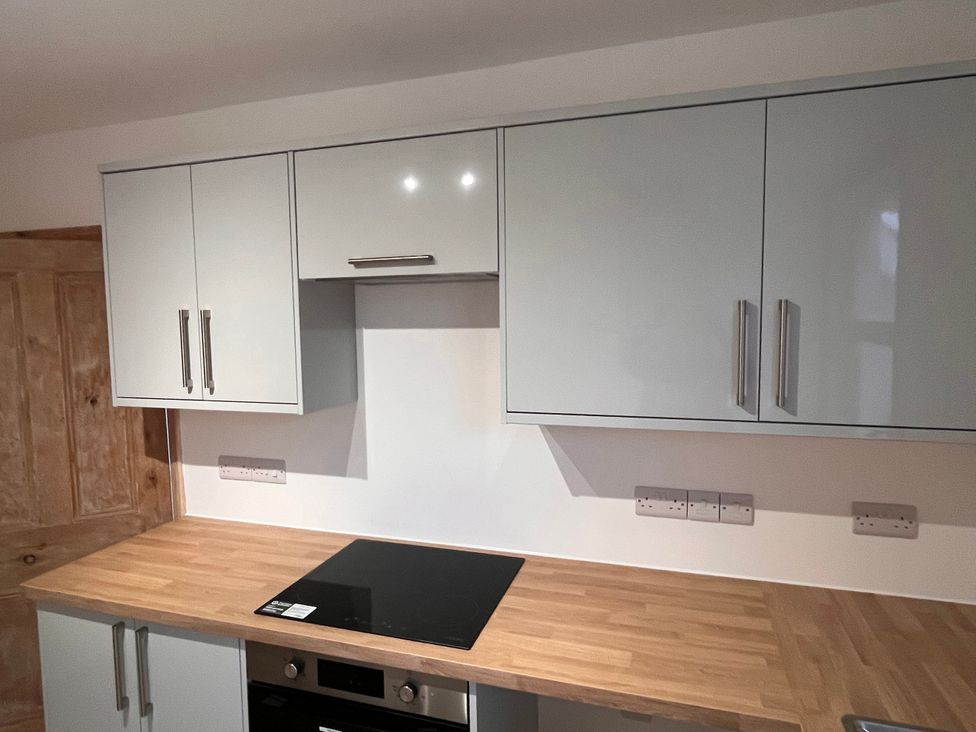 A kitchen with cabinets and an electric hob at 5a Bramber Road in Seaford