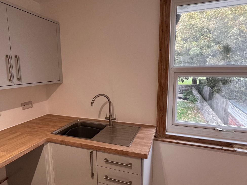 A kitchen with a sink and cabinets at 5a Bramber Road in Seaford