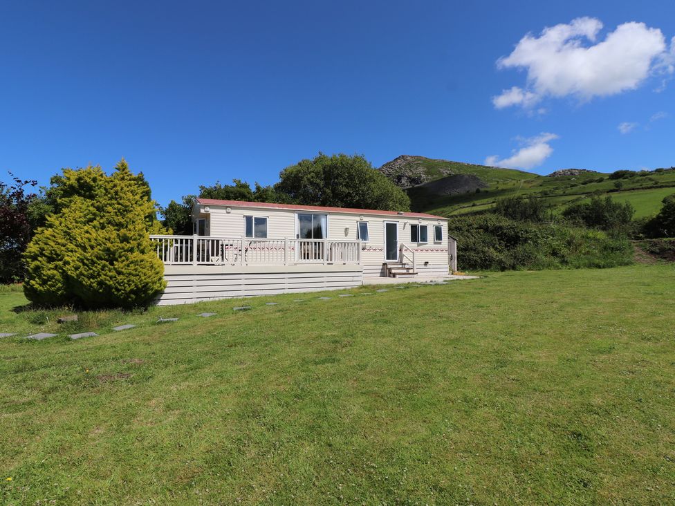 A trailer with deck in a grassy area at Mor a Mynydd in Pwllheli