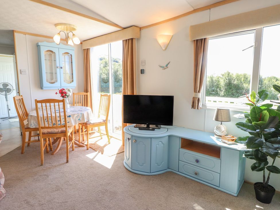 A dining room with a table and chairs at Mor a Mynydd in Pwllheli