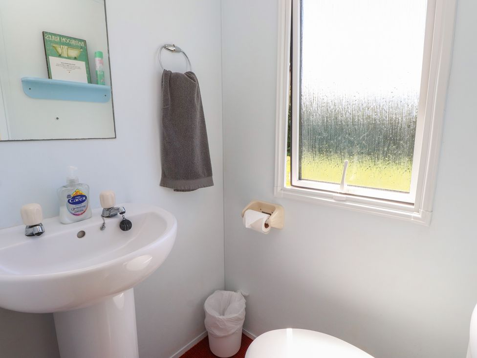 A bathroom with a sink and toilet at Mor a Mynydd in Pwllheli