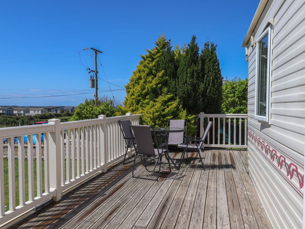 An outdoor area with a deck and seating at Mor a Mynydd in Pwllheli