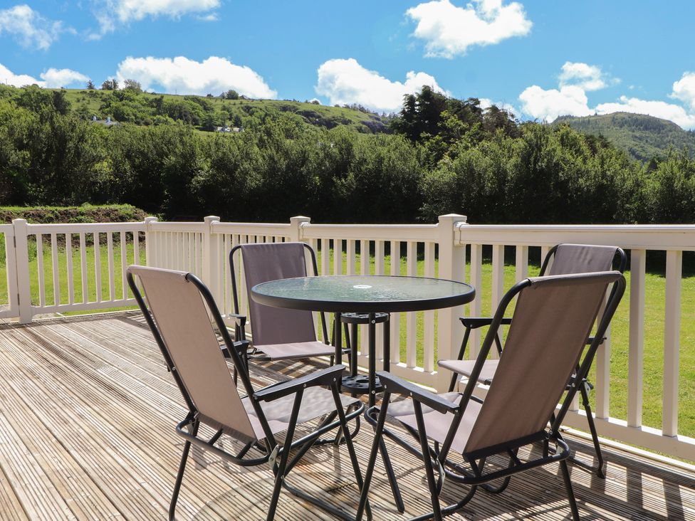 An outdoor seating area with a table and chairs at Mor a Mynydd in Pwllheli