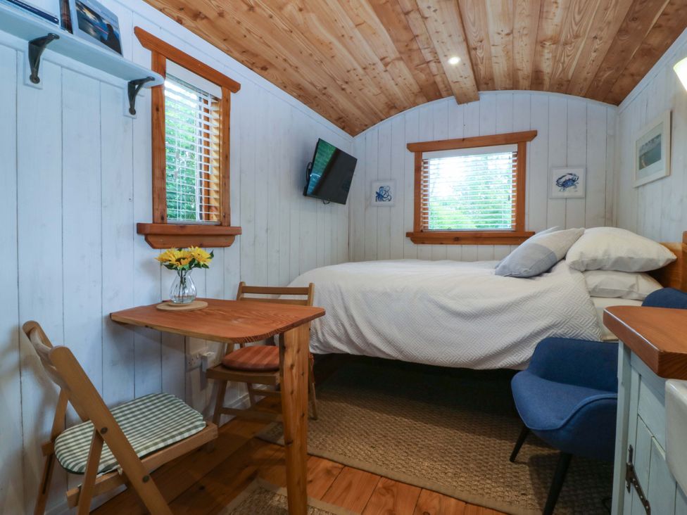 A bedroom with a bed and a table at Ardwyn in Pwllheli