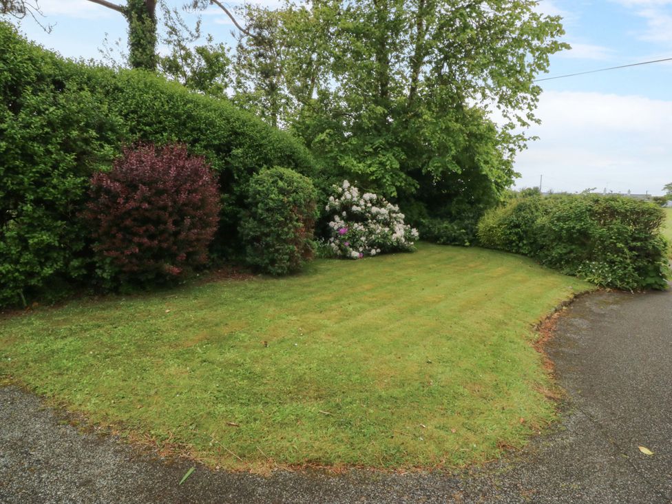A garden with grass and shrubs at Ardwyn Pwllheli