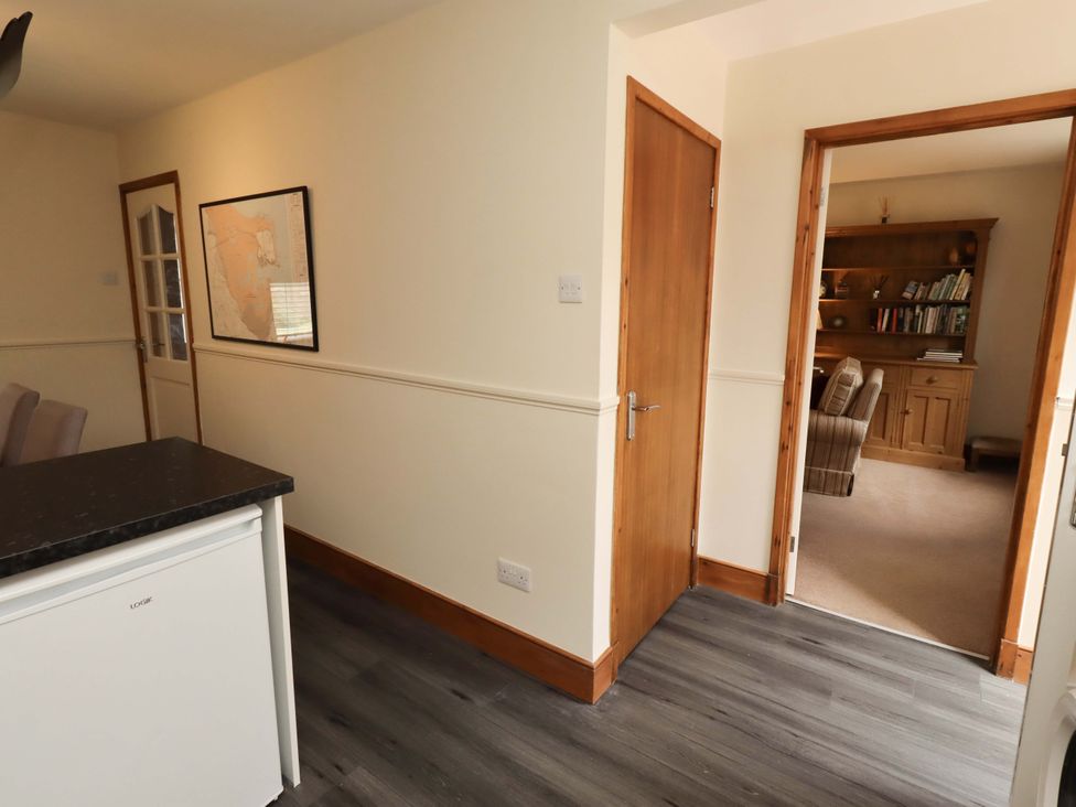 A kitchen area with a fridge and a map on the wall at Sarah's Cottage