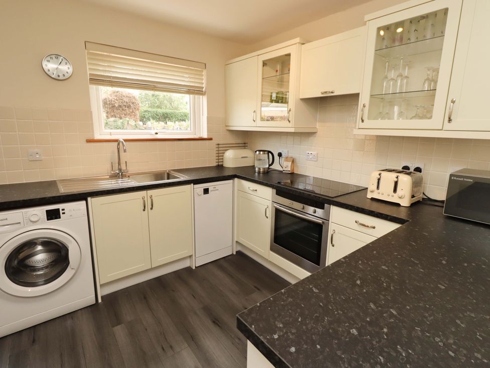 A kitchen with appliances and cabinetry at Sarah's Cottage