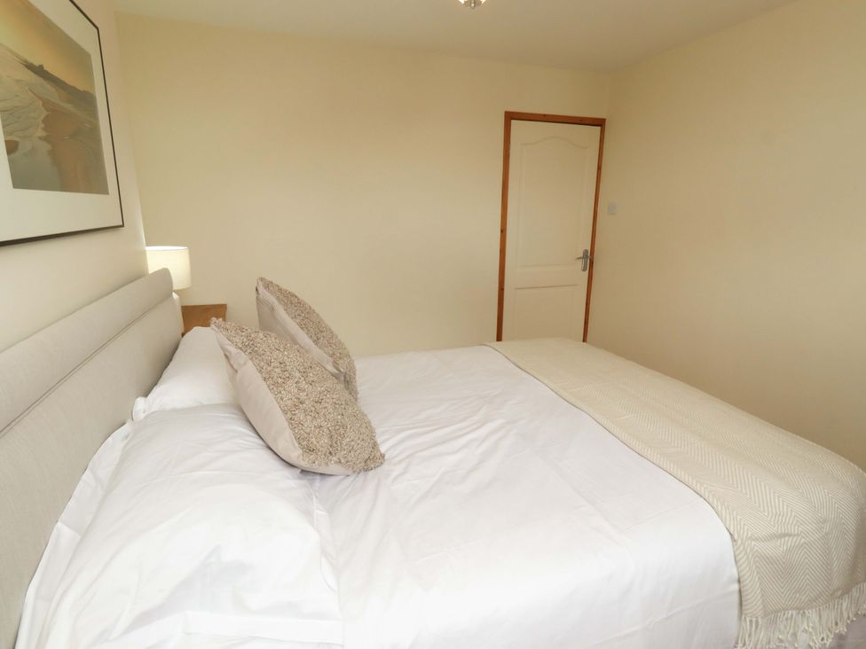 A bedroom with a bed and lamp at Sarah's Cottage