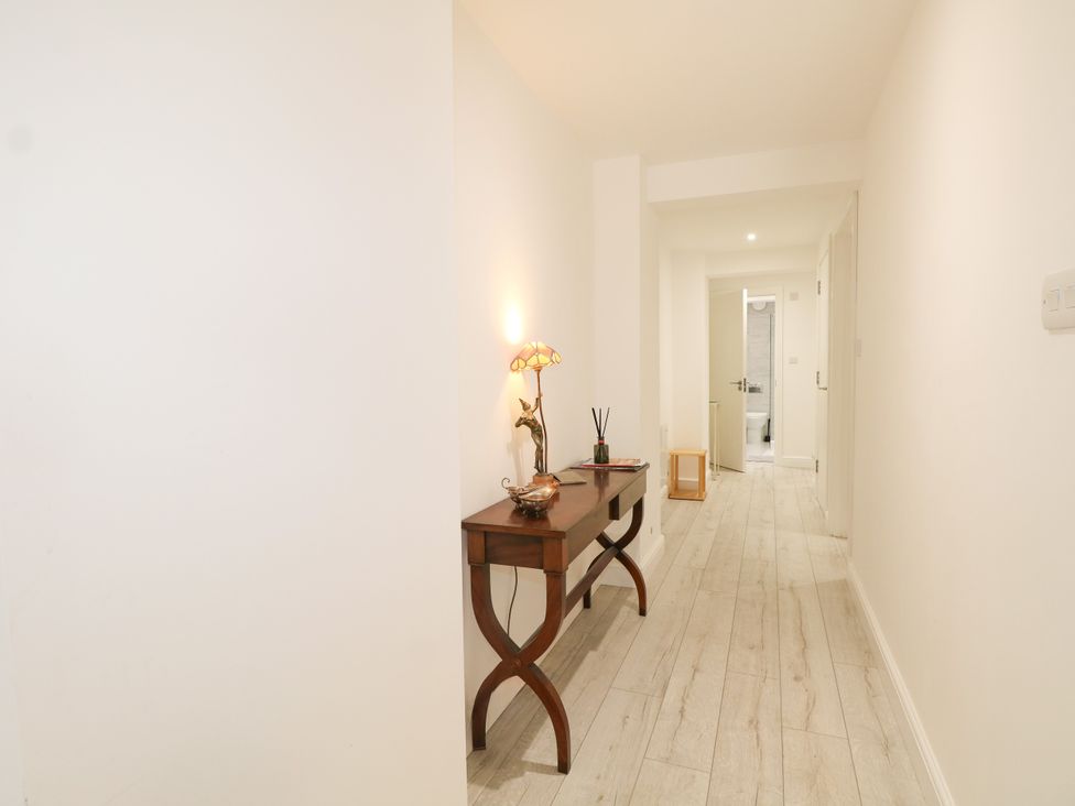 A hallway with a table and lamp at 2 Bed in Bishop's Waltham