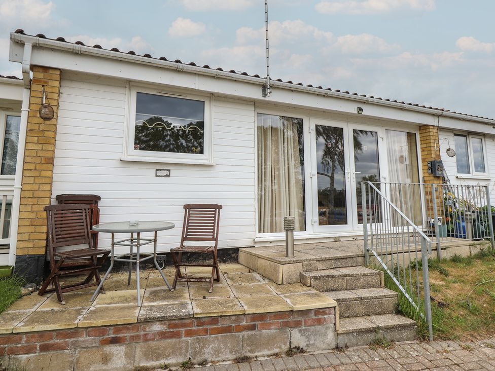 An outdoor seating area with chairs and a table at Cosy Home Great Yarmouth