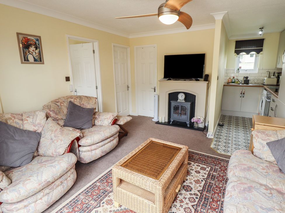 A living room with a coffee table and television at Cosy Home in Great Yarmouth