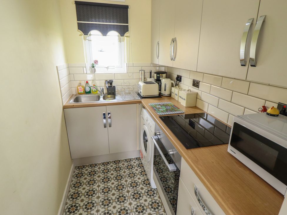 A kitchen with appliances and sink at Cosy Home in Great Yarmouth