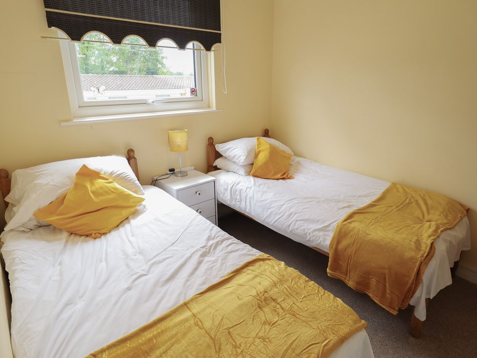 A bedroom with two single beds and a lamp at Cosy Home in Great Yarmouth