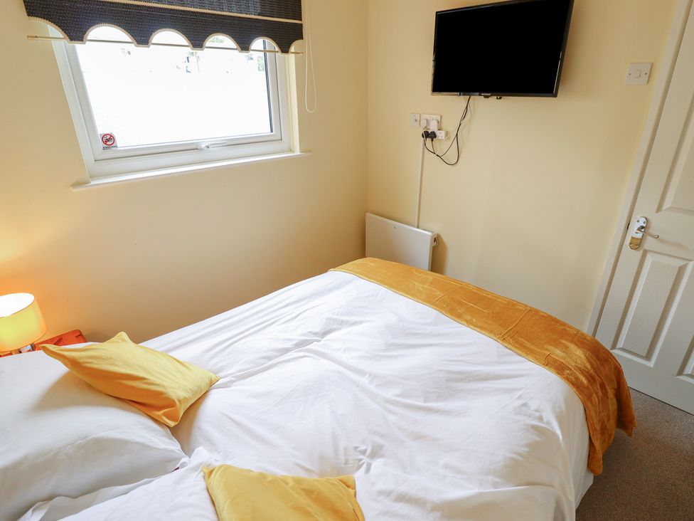 A bedroom with a bed and television at Cosy Home in Great Yarmouth