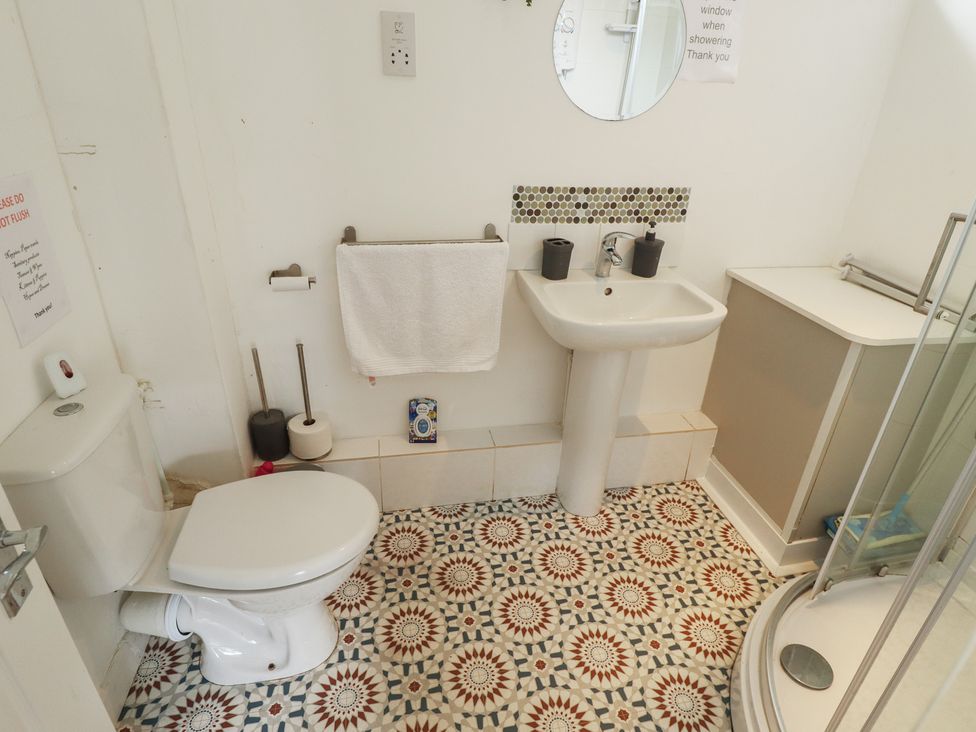 A bathroom with a toilet, sink, and shower at Cosy Home in Great Yarmouth