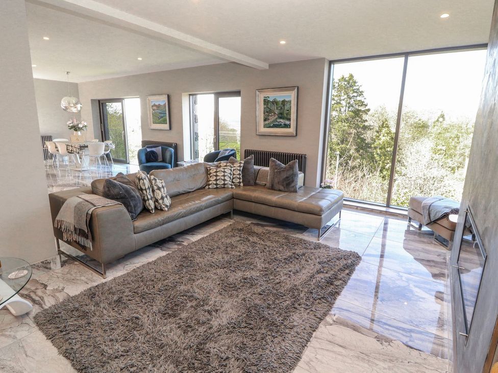 A living room with a sofa and a dining area at Midways, Windermere