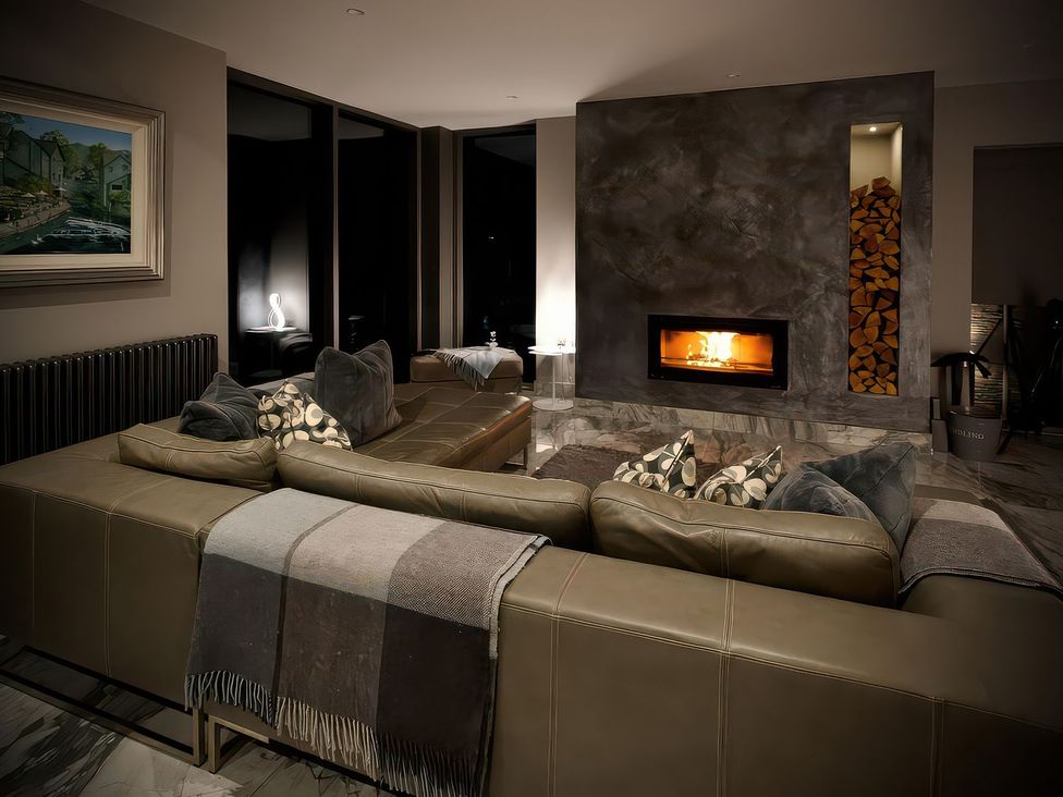 A living room with a sofa and a fireplace at Midways in Windermere