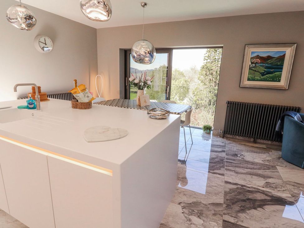 A kitchen with a sink and bar stools at Midways in Windermere