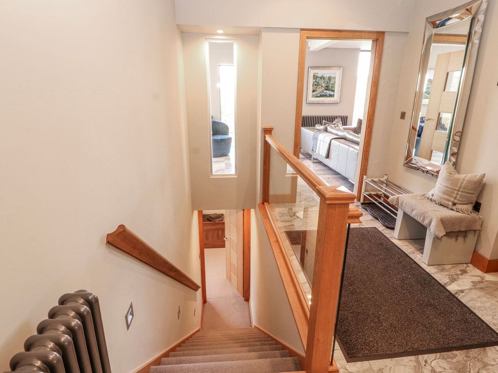 A hallway with a staircase and seating area at Midways in Windermere
