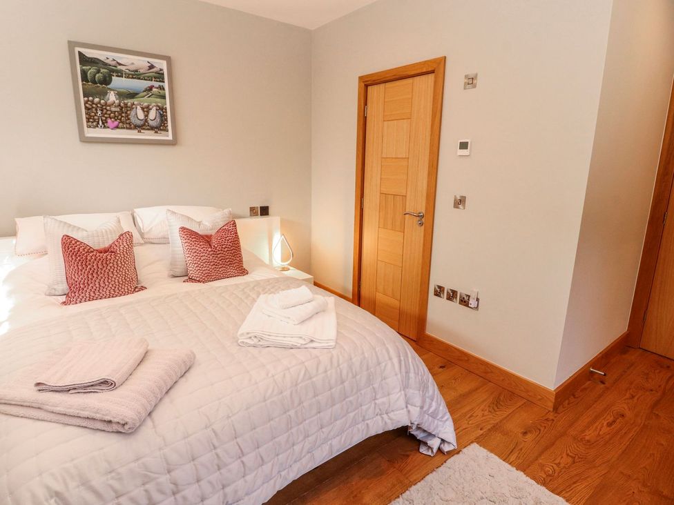 A bedroom with a bed and artwork at Midways in Windermere