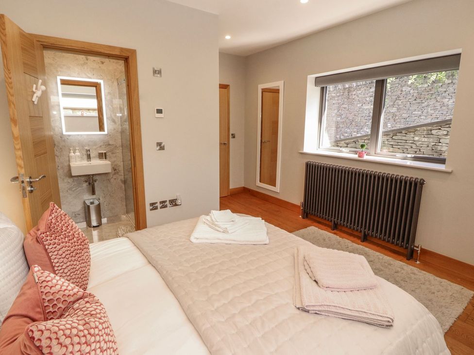 A bedroom with a bed and wash basin at Midways Windermere