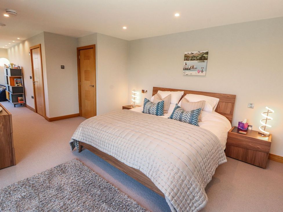 A bedroom with a bed and bedside tables at Midways in Windermere