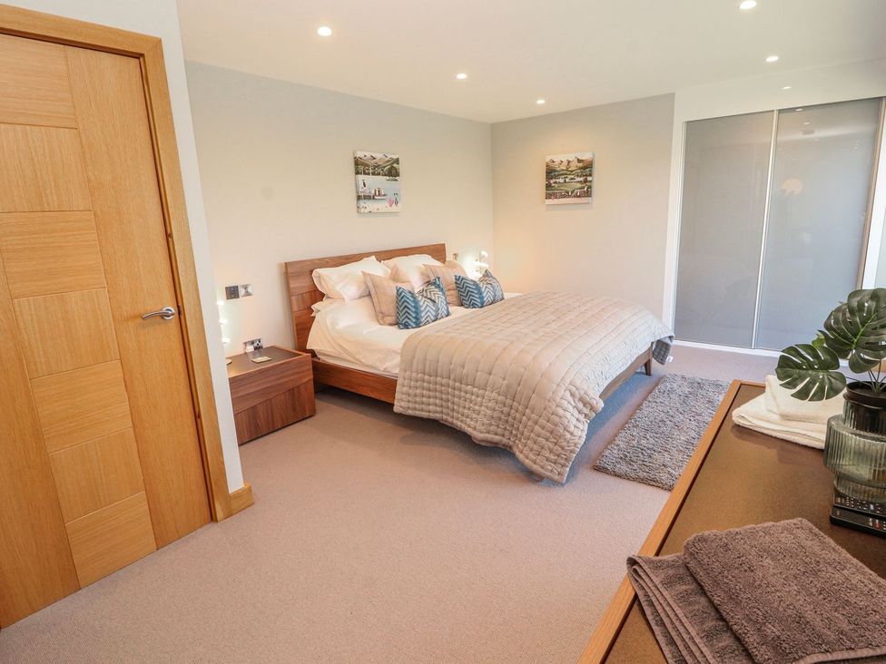 A bedroom with a bed and bedside tables at Midways in Windermere