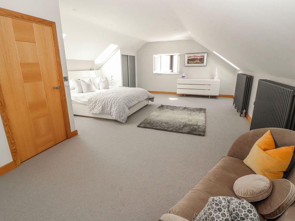 A bedroom with a bed and a sofa at Midways in Windermere